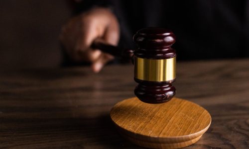 A gavel striking a sound block, symbolizing justice and legal authority in a courtroom setting.